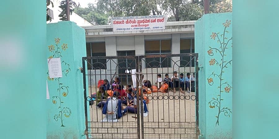 ಶಾಲಾ ಭೂ ವಿವಾದ: ತರಗತಿಗಳಲ್ಲಿ ಕೂರಲು ಸಾಧ್ಯವಾಗದೆ ಬಯಲಿನಲ್ಲಿ ಕುಳಿತು ಮಕ್ಕಳ ವಿದ್ಯಾಭ್ಯಾಸ!